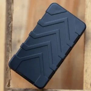 A rectangular electronic device in matte black sitting on a wooden surface.